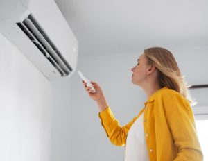 ductless-mini-split-with-woman-and-remote